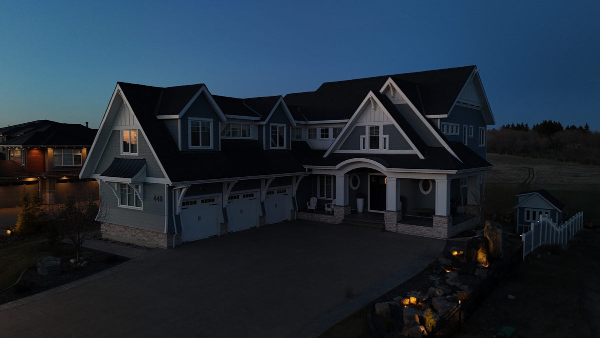 Drone view of a home with colour permanent lighting on the gables